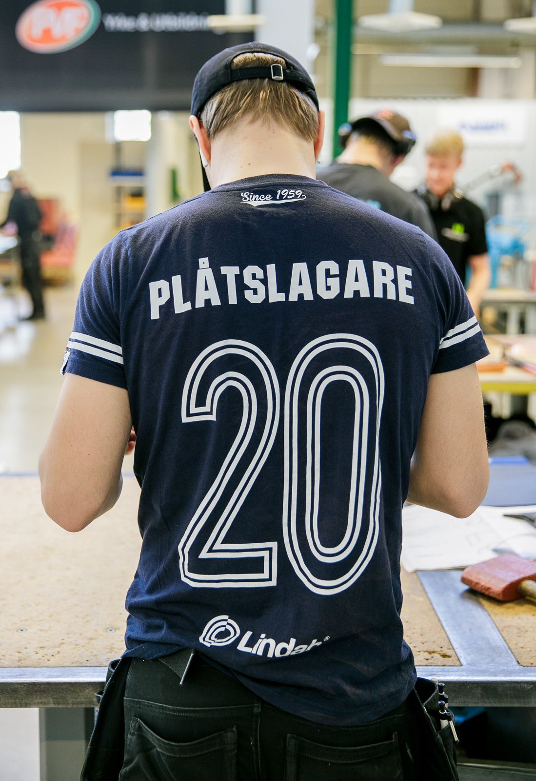 Navy blue t-shirts with white text and numbers being worn at an event.