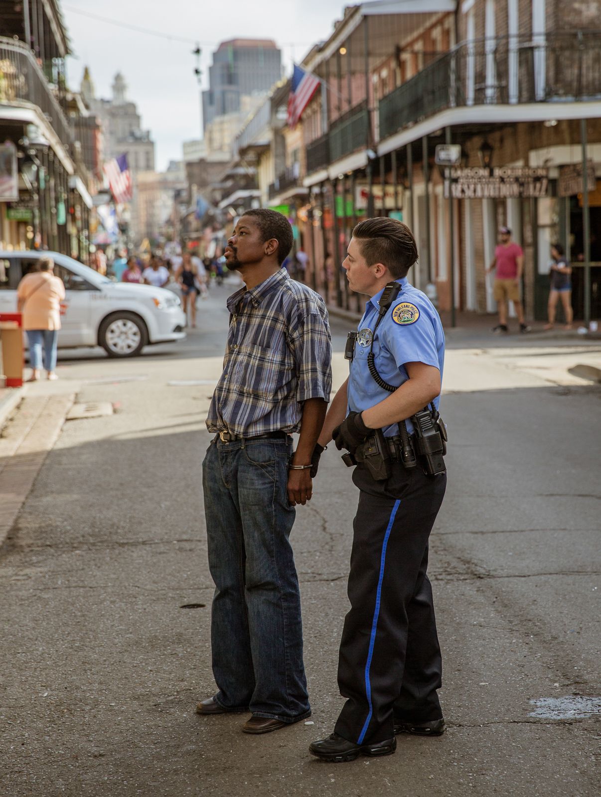 Police officers and civilians interact on a historic French Quarter street in New Orleans.