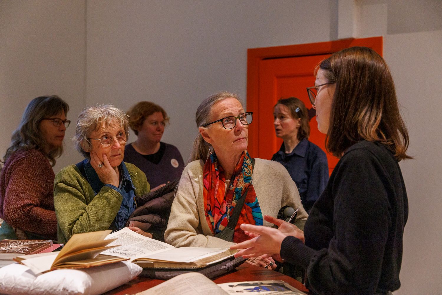 Group discussion taking place around a table with books and papers.