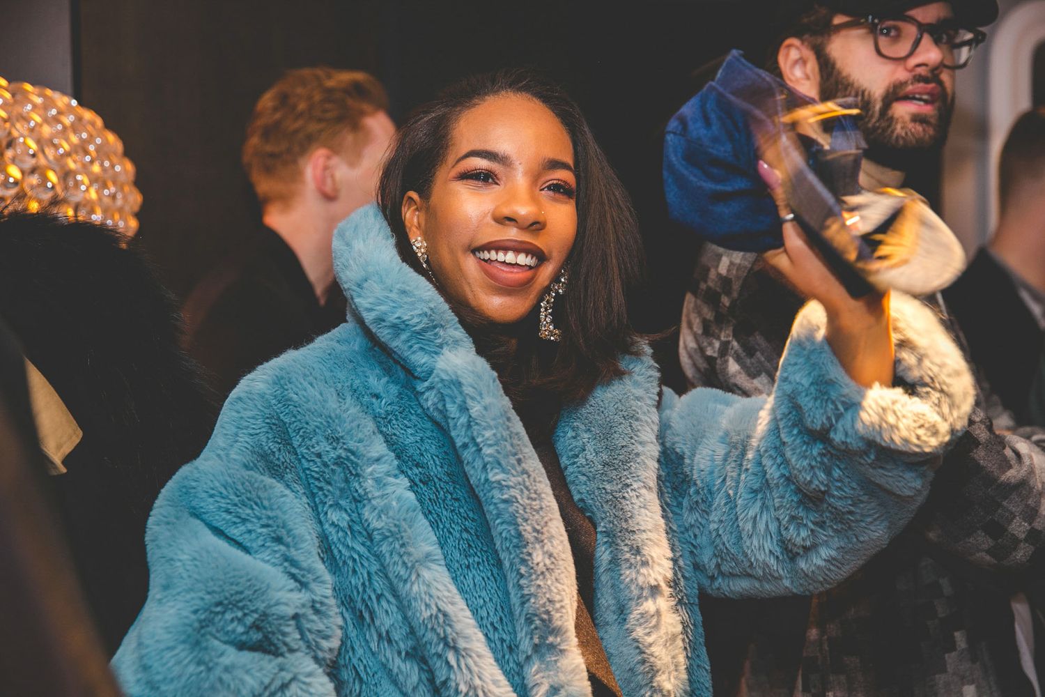 Attendees engaging and smiling during an indoor event.