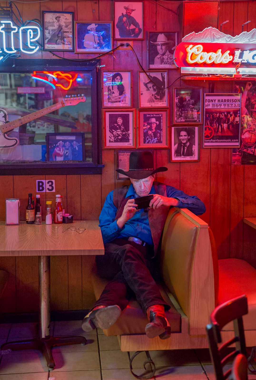 Dimly lit bar interior with red neon signs and wood paneled walls.