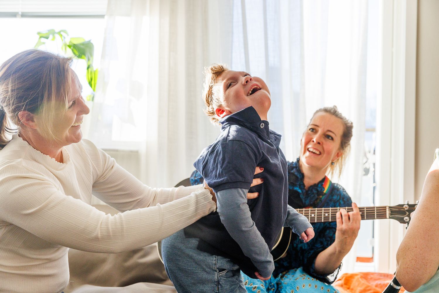 People participate in an interactive therapy or music session near bright windows.