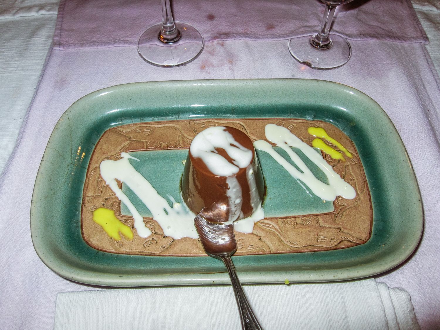 Dessert plates with chocolate sauce and cream arranged in a row.