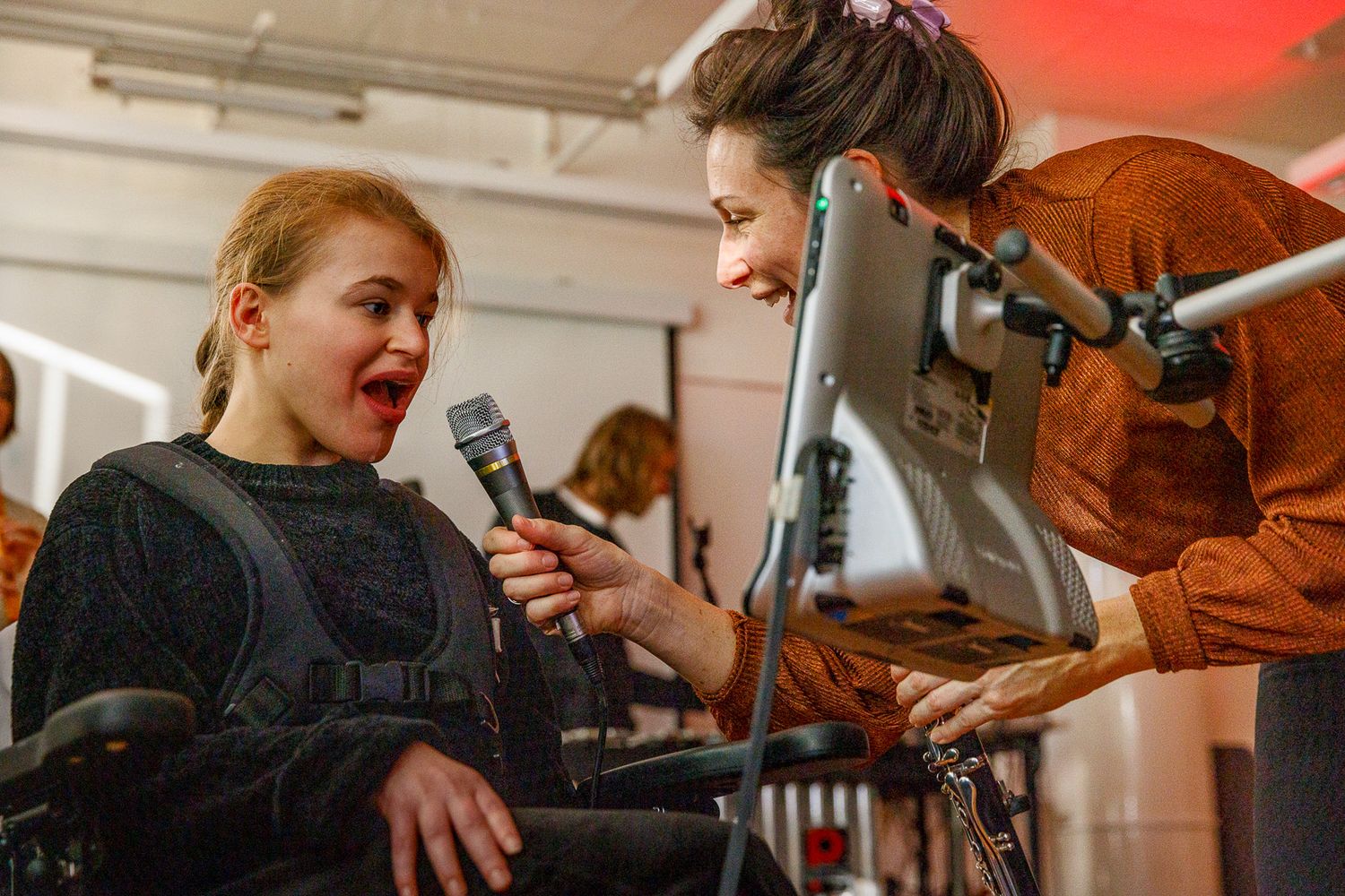 Musicians perform and interact during a bright indoor session with instruments.