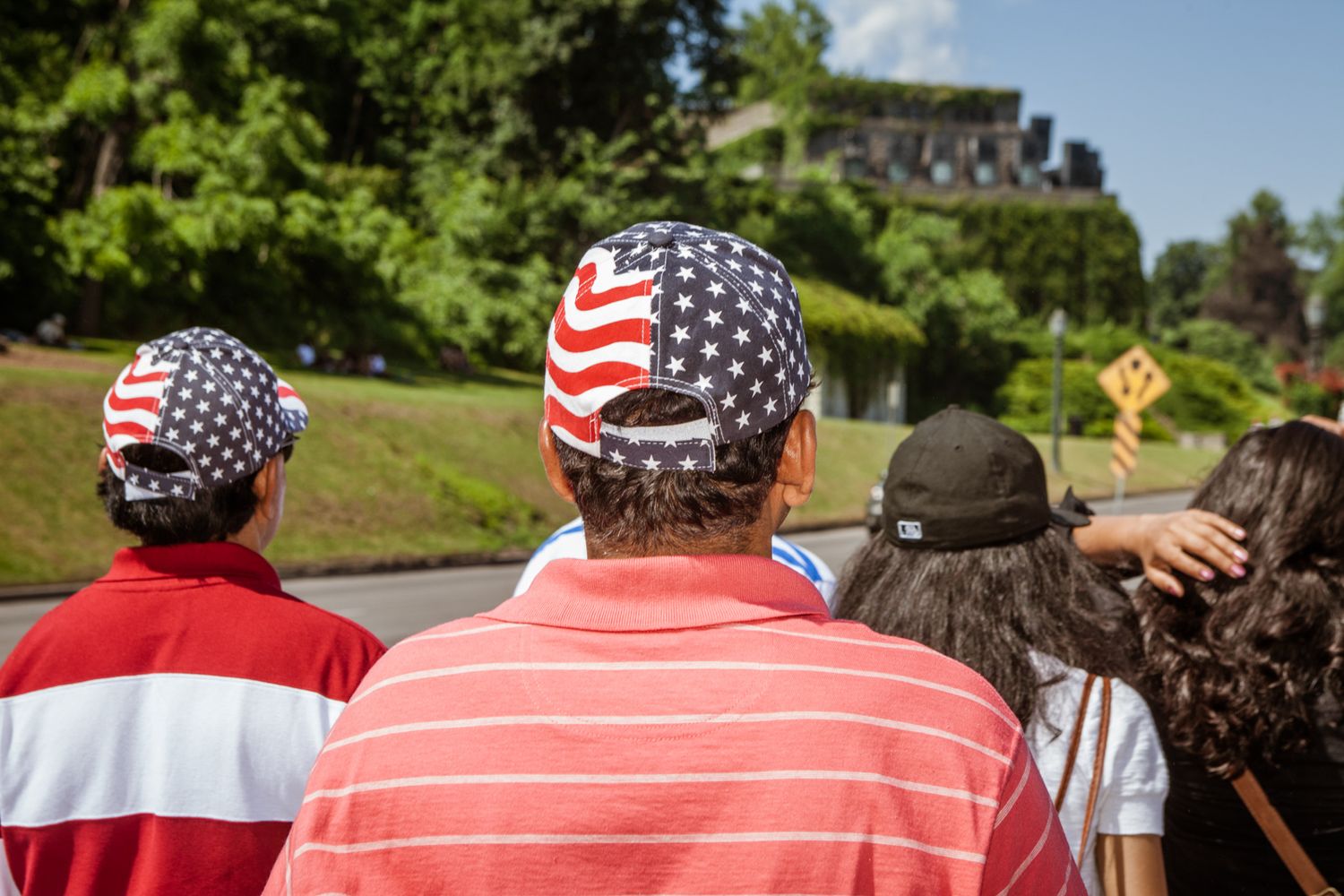 Group of people wearing American flag-themed clothing gathered outdoors on a sunny day.