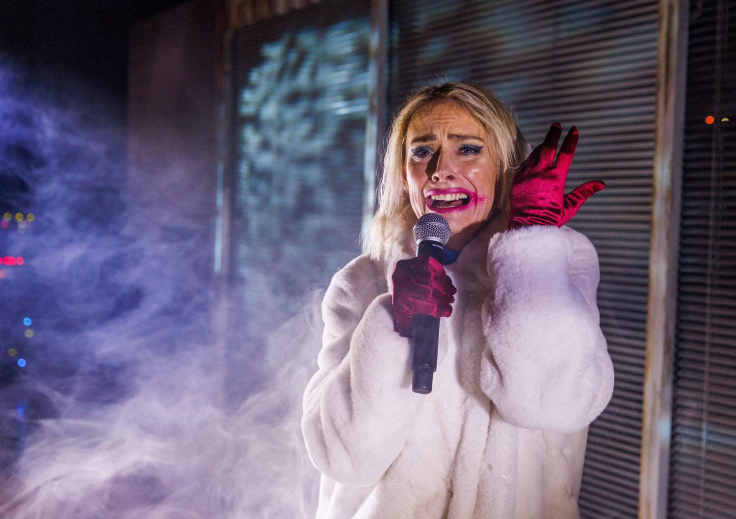 Dramatic scene with purple smoke effects and person in white coat.