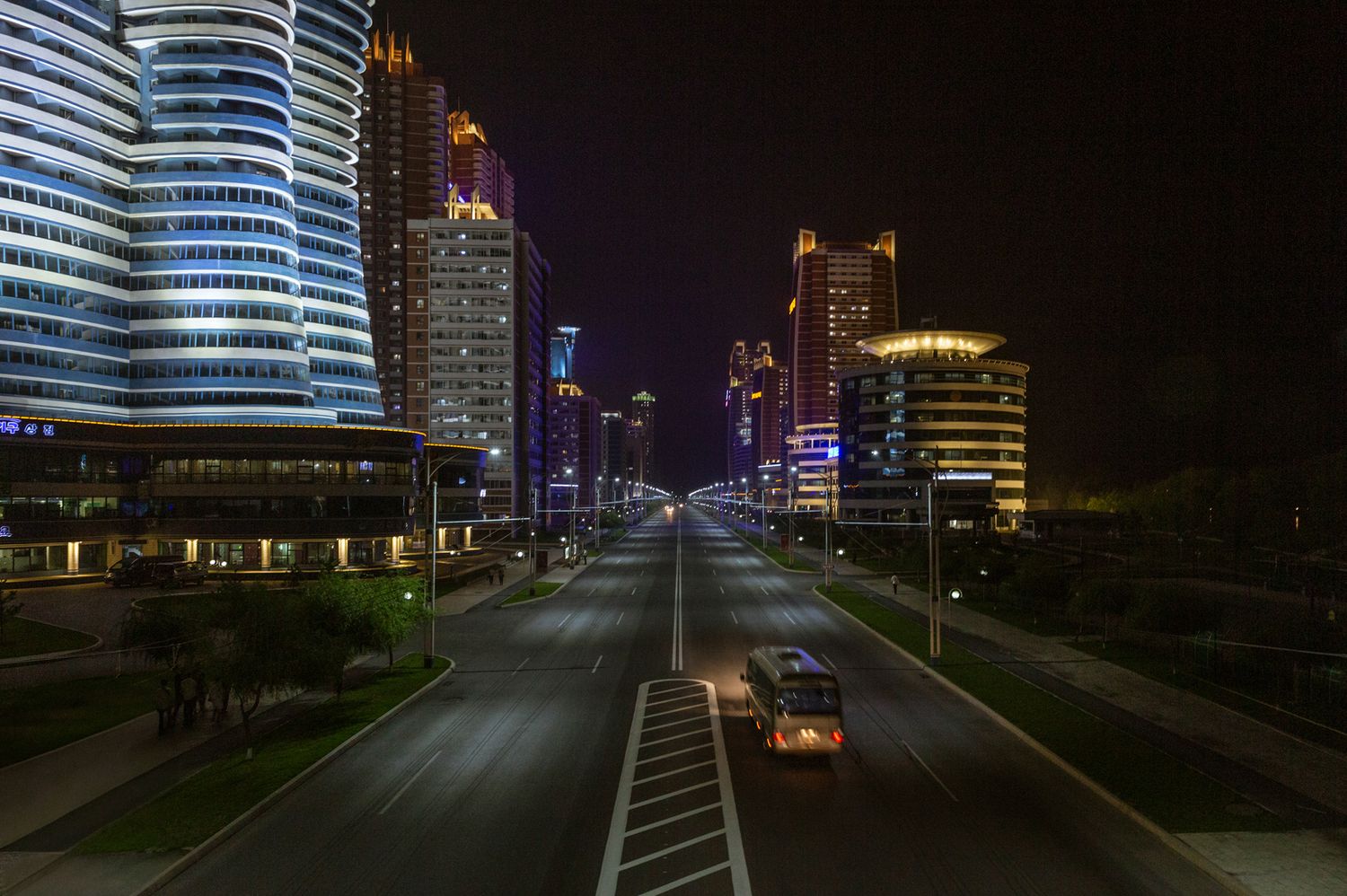 Modern illuminated buildings and streets in Pyongyang at night.