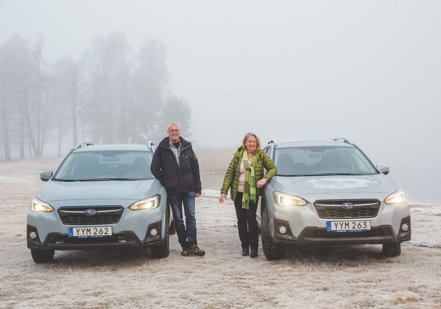 Cars parked in foggy conditions on a misty road.