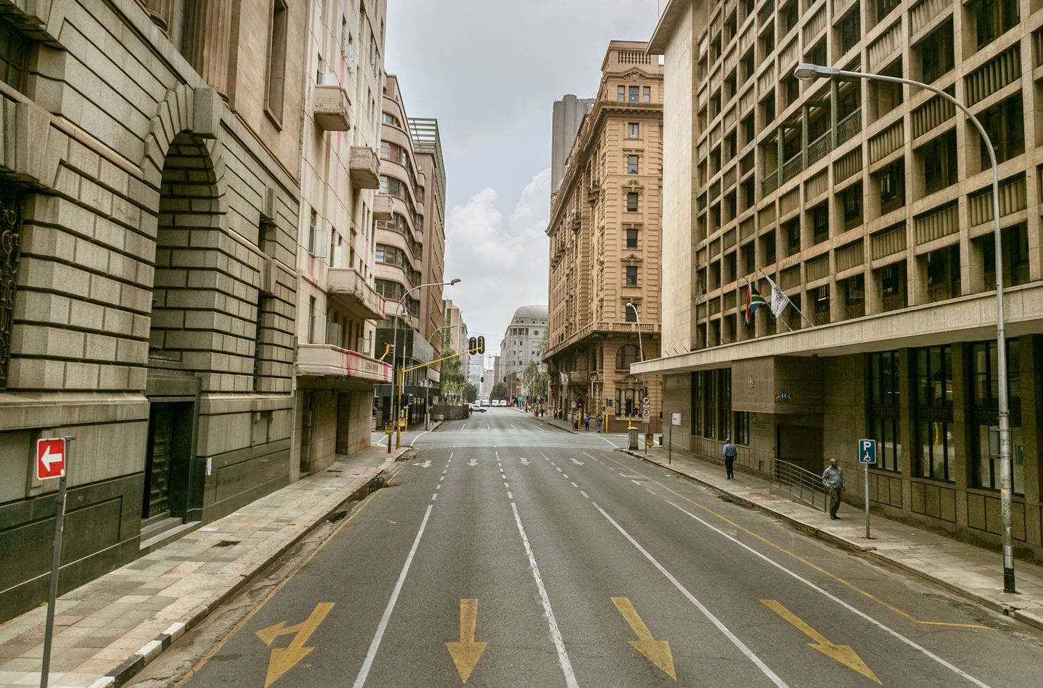 Empty urban street with historic buildings and yellow road markings stretching into the distance.
