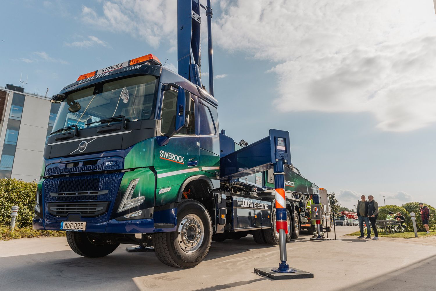 Line of commercial trucks and vehicles displayed at an outdoor event.