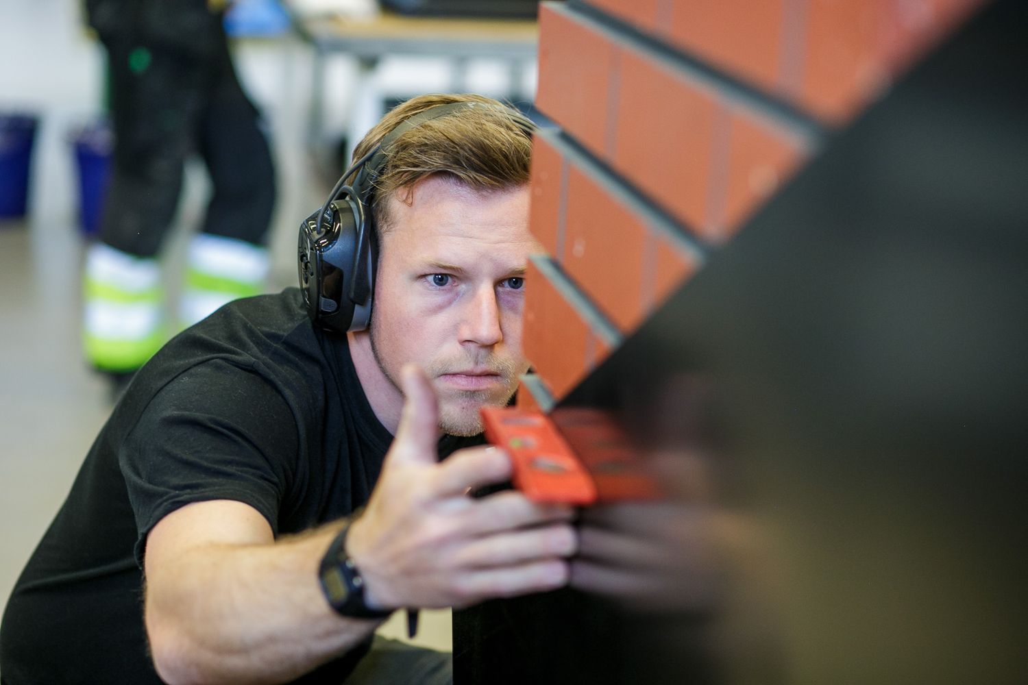 Person wearing headphones working at industrial workstation.