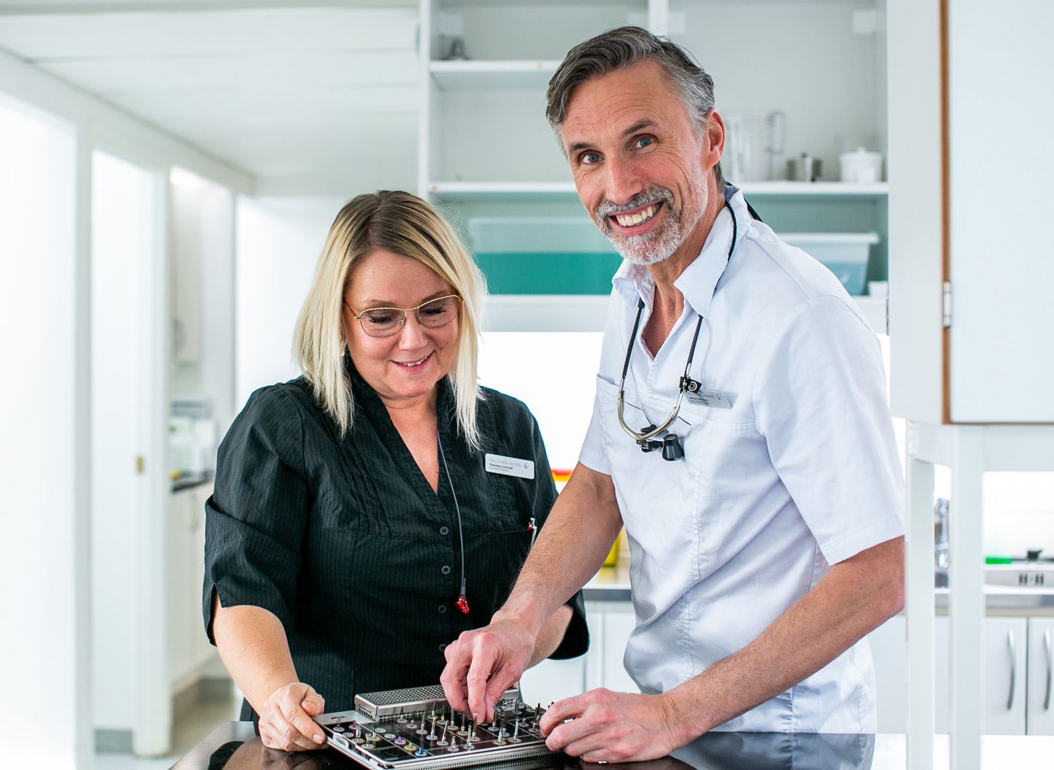 Two medical professionals collaborating at computer workstation in clinical setting.