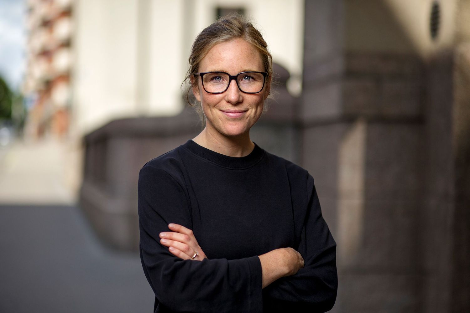 Professionellt utomhusporträtt med mjuk belysning och arkitektoniska element i bakgrunden