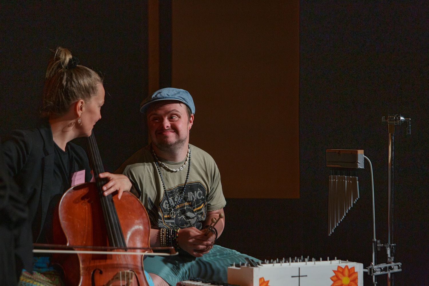 Musicians rehearse together in a dimly lit studio space with instruments.