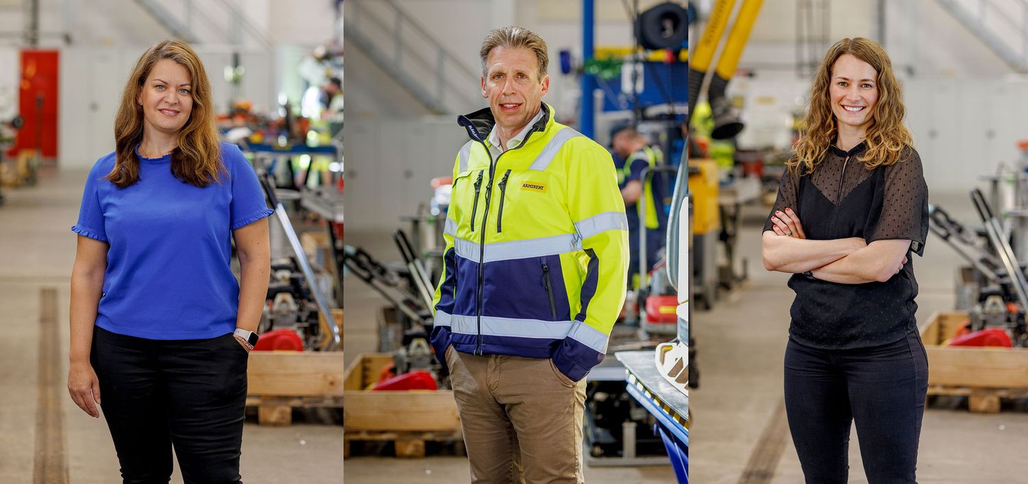 Tre yrkesverksamma i olika arbetskläder står i en industriell miljö med utrustning i bakgrunden