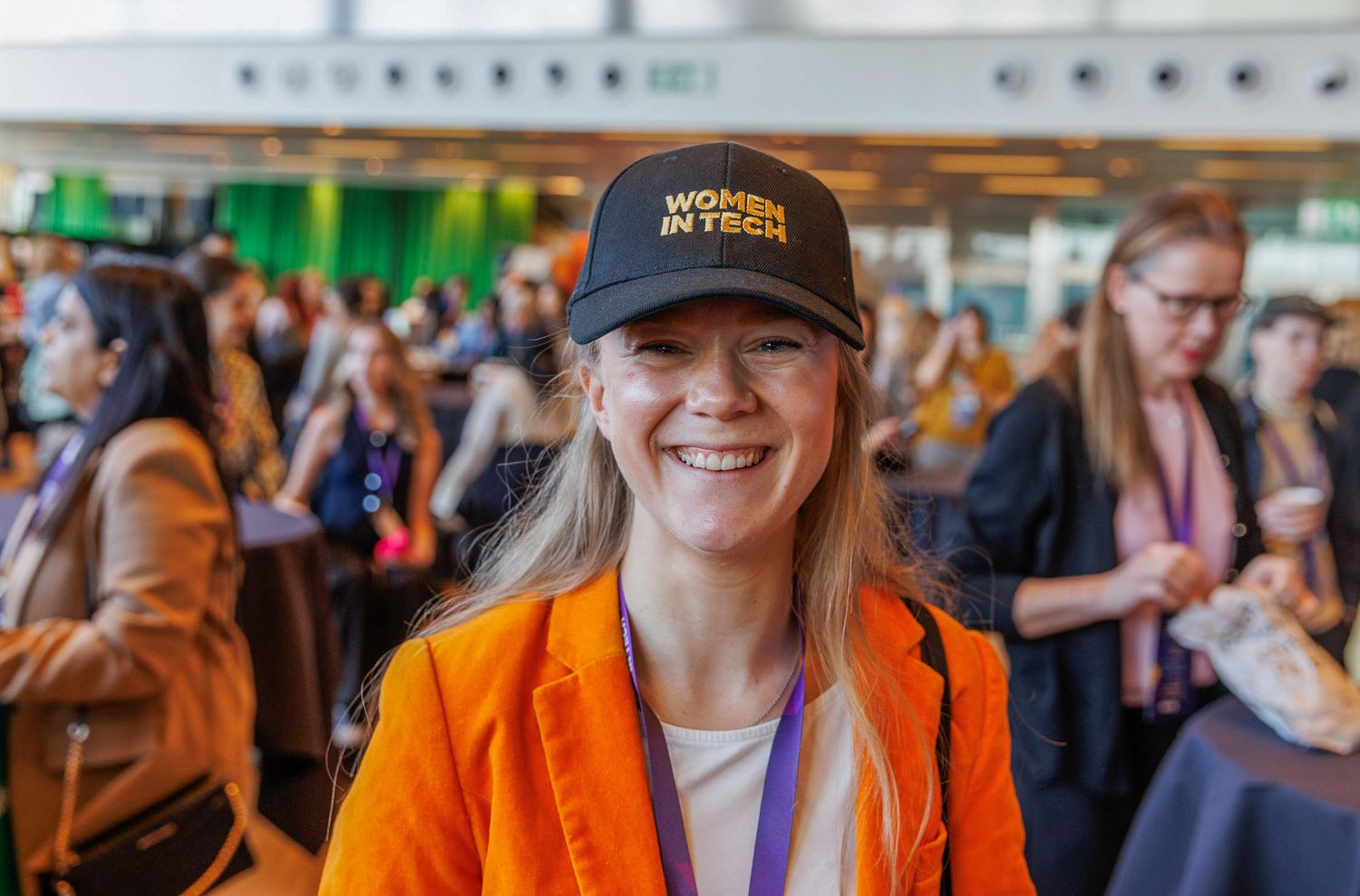 Conference attendees wearing branded merchandise gather at a tech event.