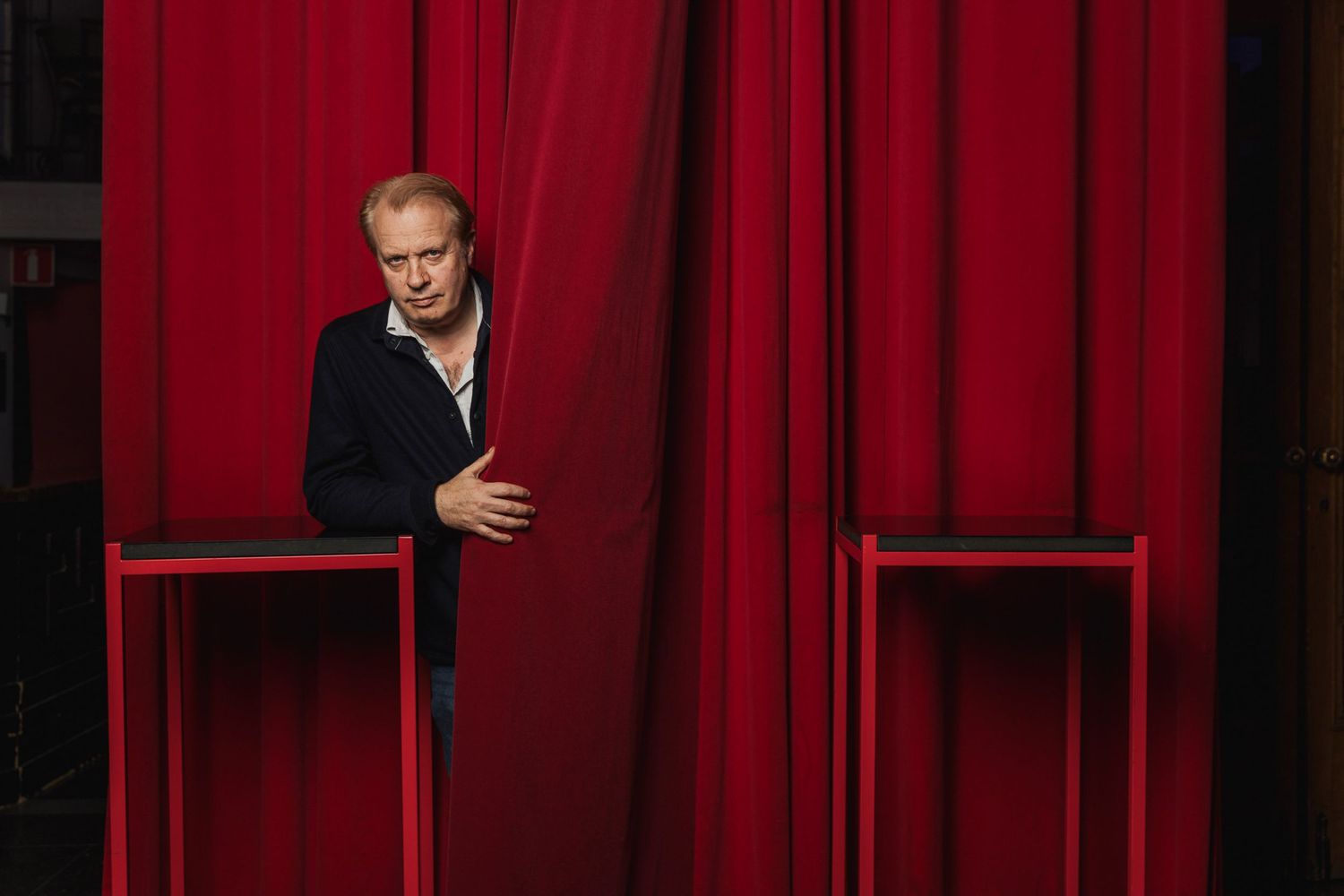 Theater setting with deep red curtains creating dramatic atmosphere.