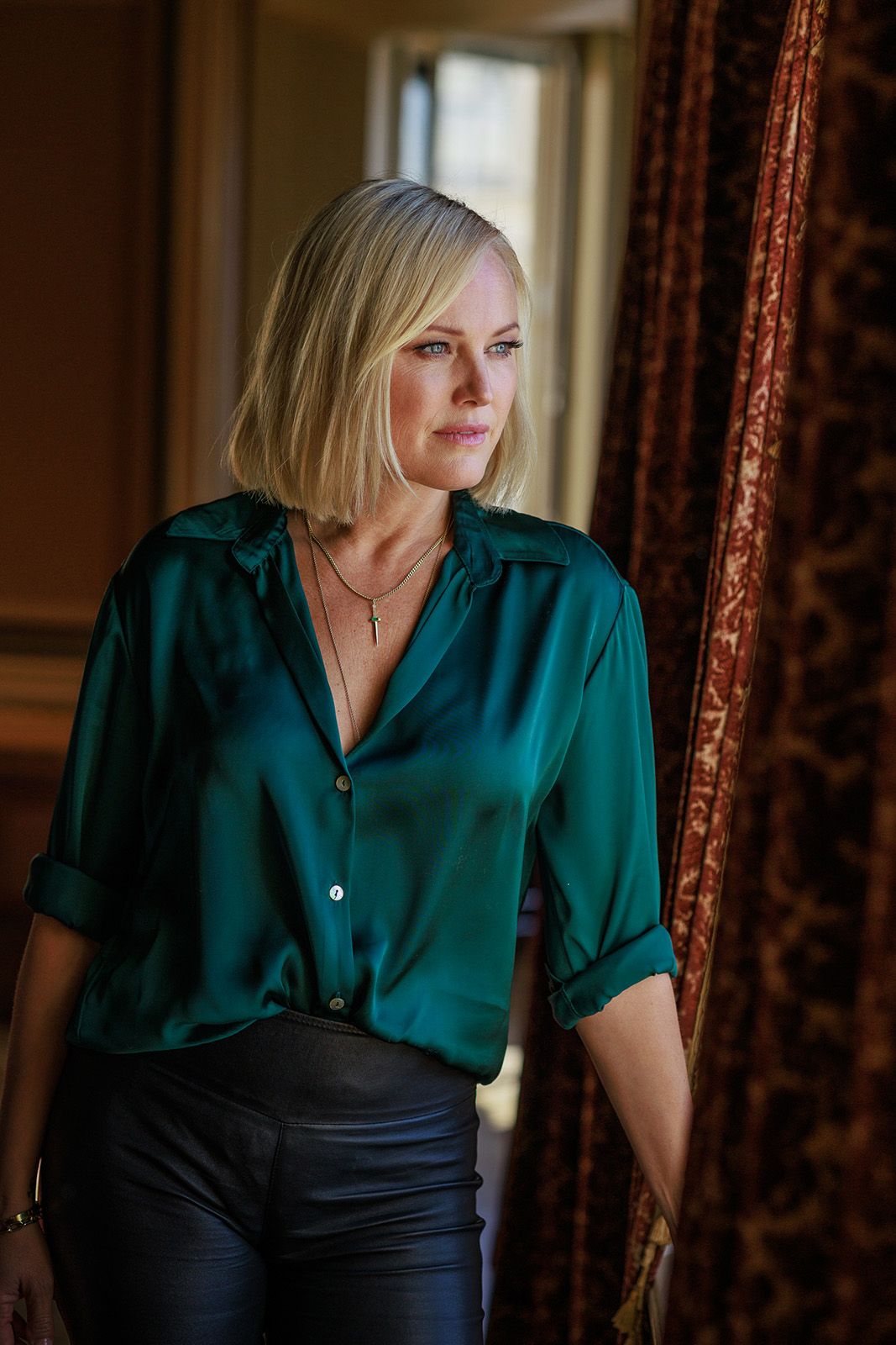 Dramatic lighting portraits in an elegant room with dark green silk blouse.