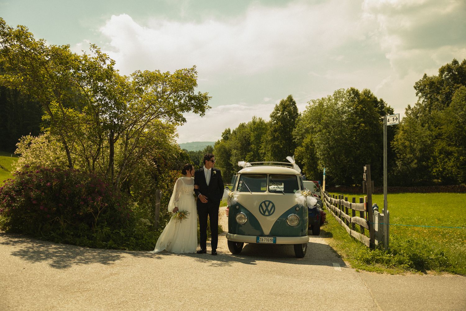 Bride arriving at San Costantino church with a vintage minivan, wedding in the Dolomites