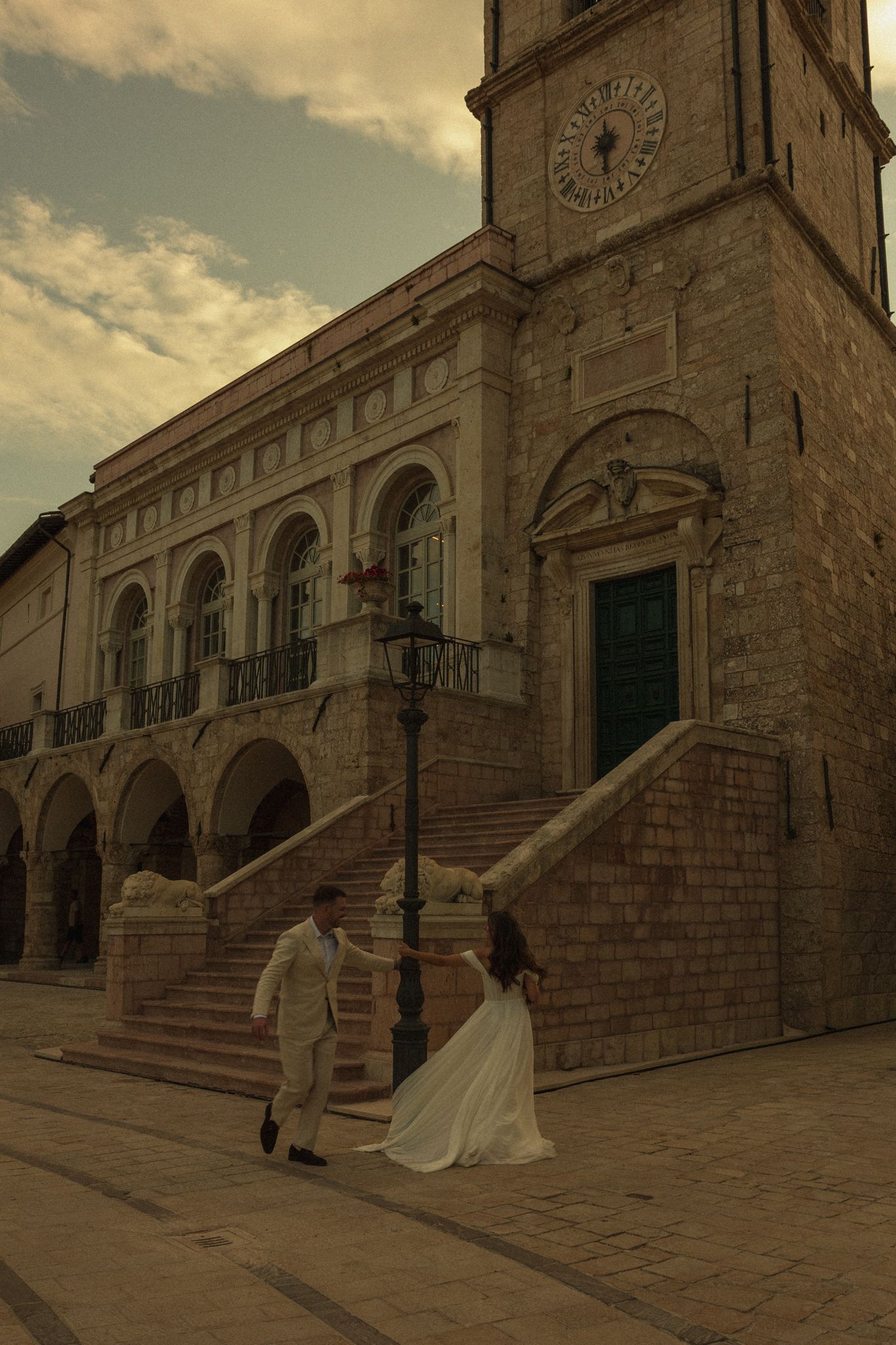 Couple walking through the historic piazza of Norcia, Umbria