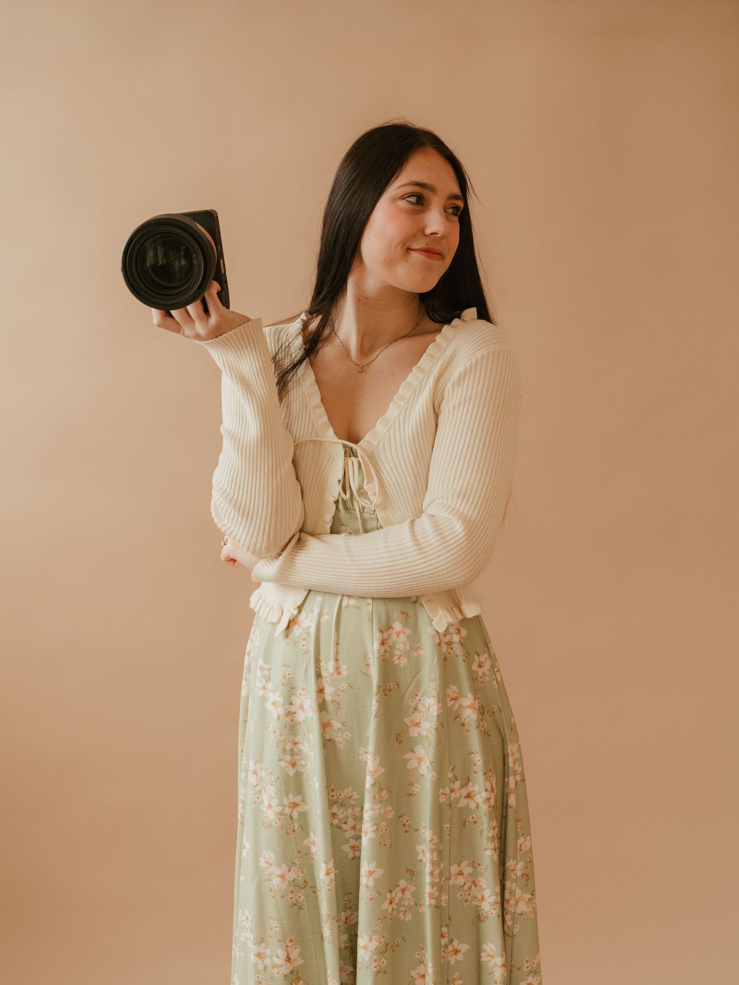 Portrait of Ashley Buning, photographer, standing in a natural light studio smiling