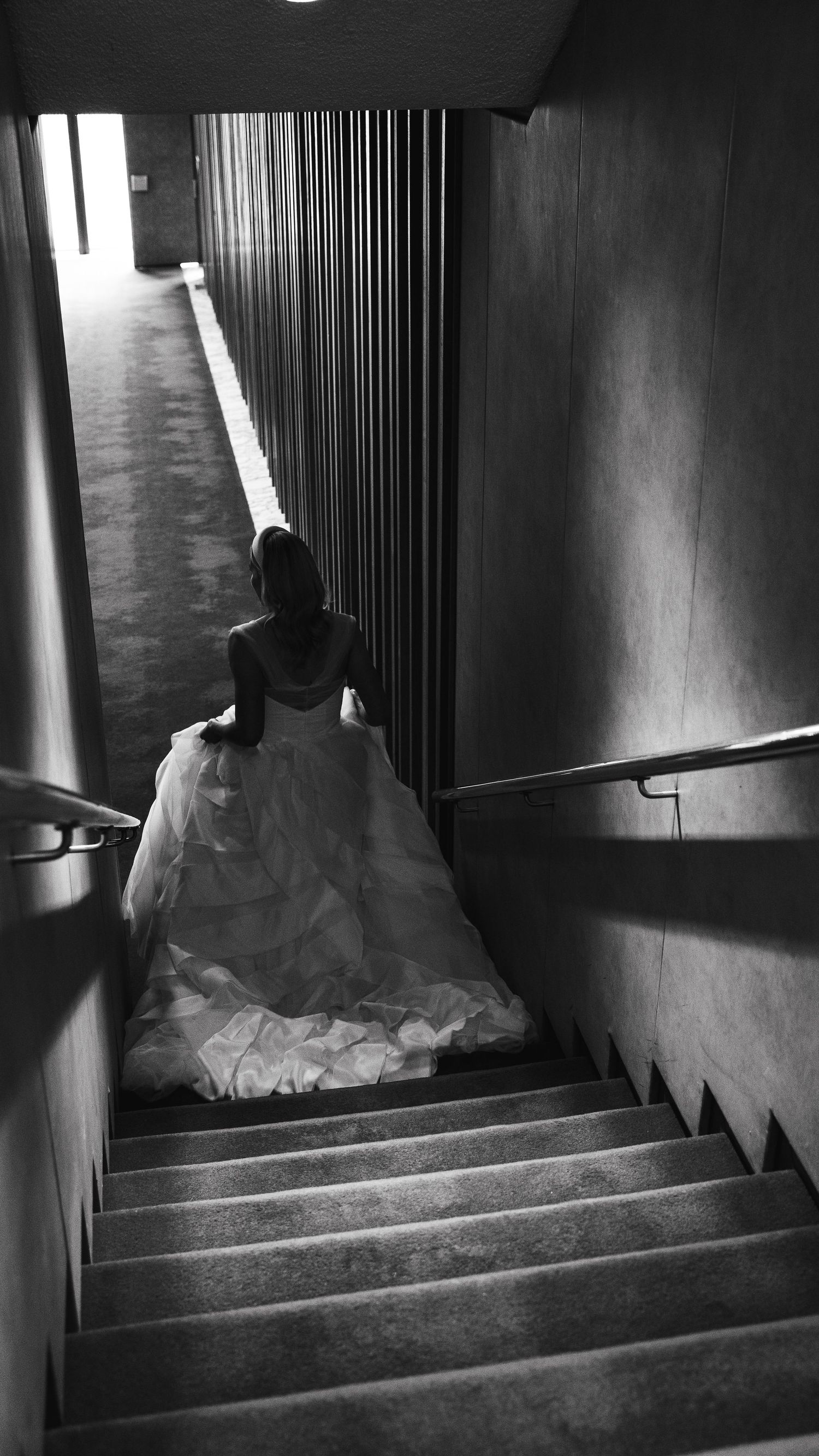 Bride walks down some stairs, dress follows