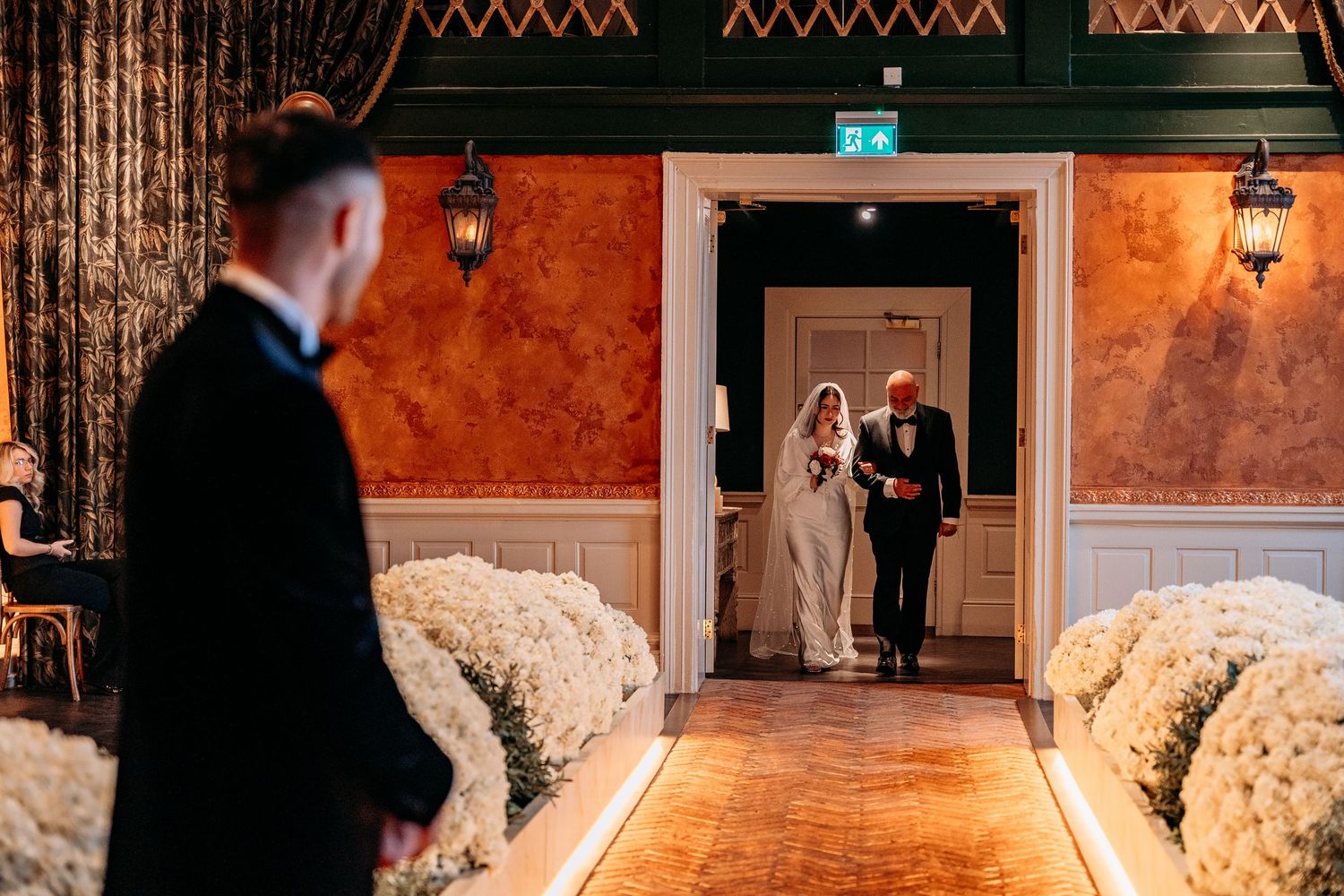 Groom watches bride-to-be walk down the aisle with her Dad.
