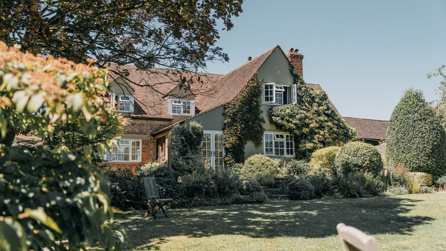 Venue with vines and bushes on the side of building.