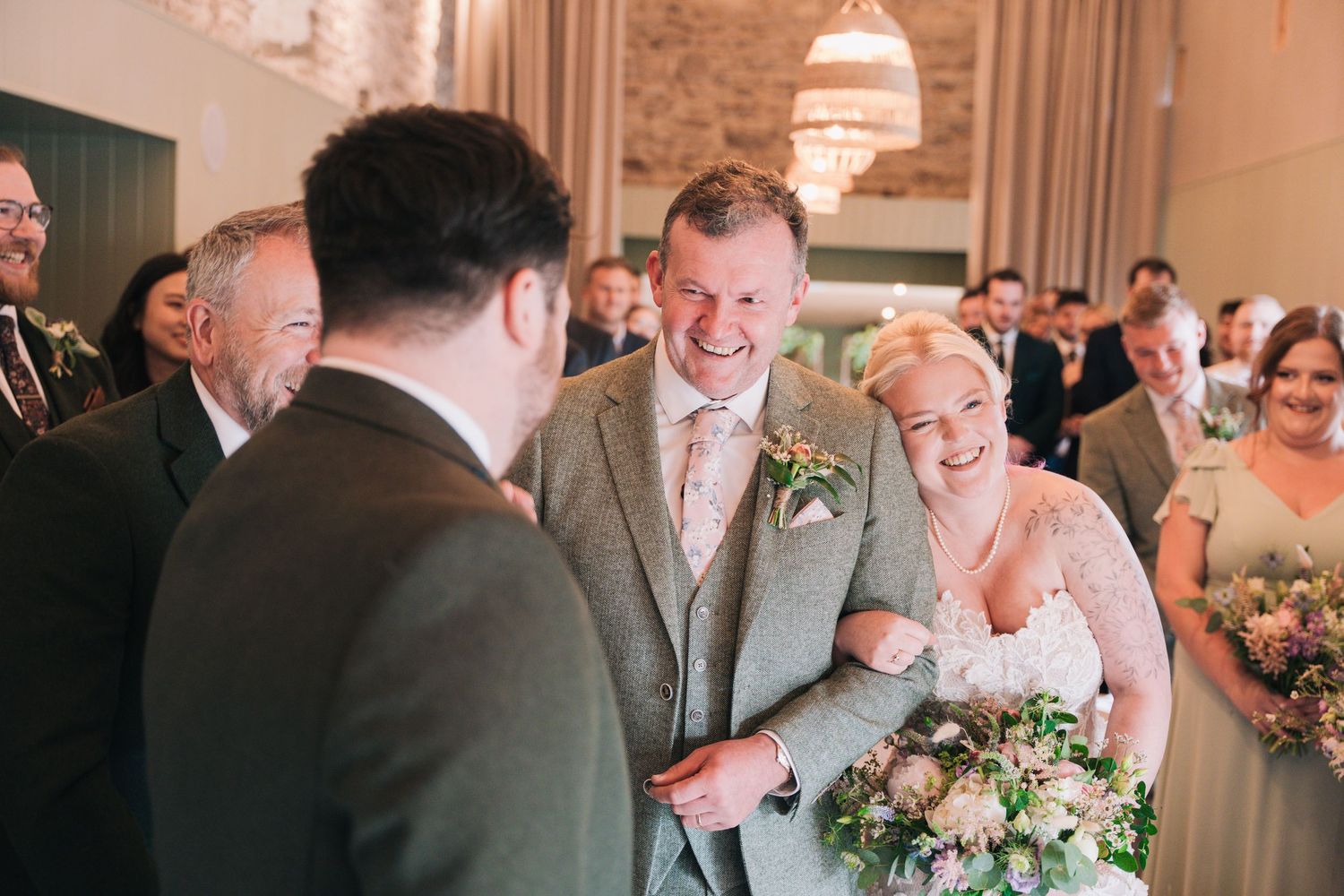 Bride leans her head onto Father with a smile on her face