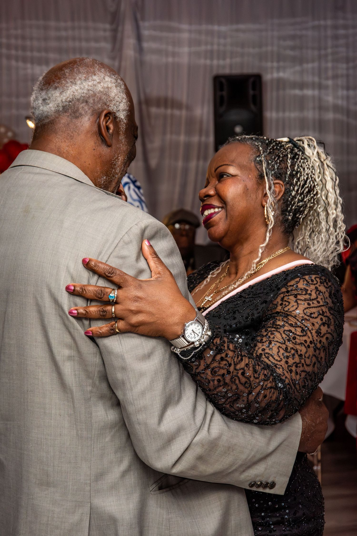 Couple sharing a joyful slow dance together at an elegant indoor celebration.