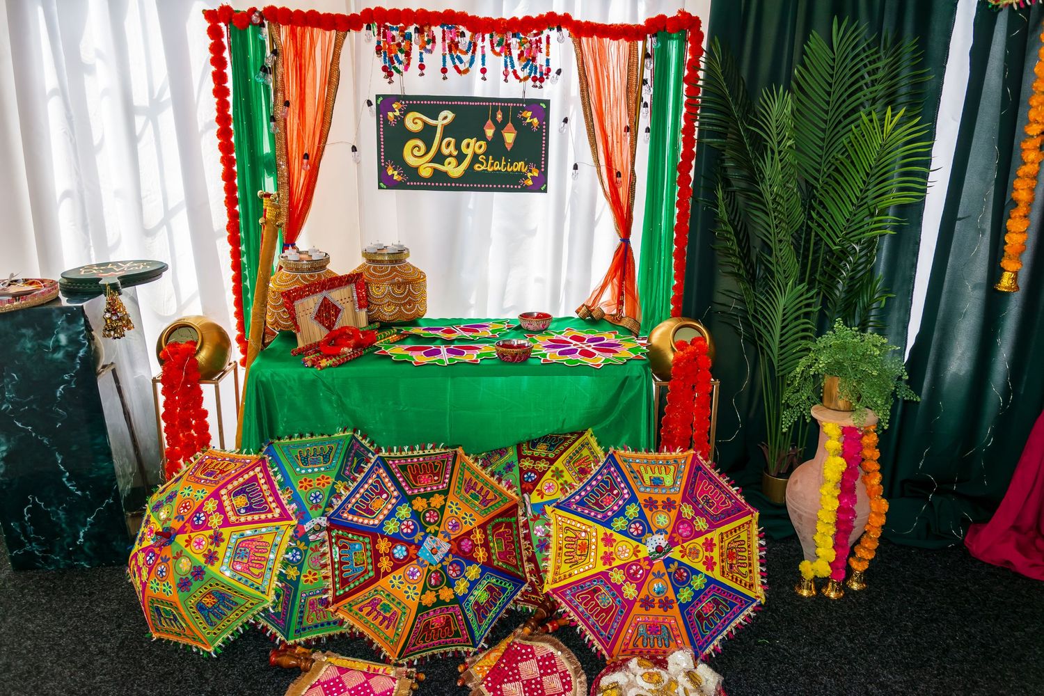 Colorful Indian Mehndi celebration setup with embroidered umbrellas and vibrant Lagaan Baithak signage.