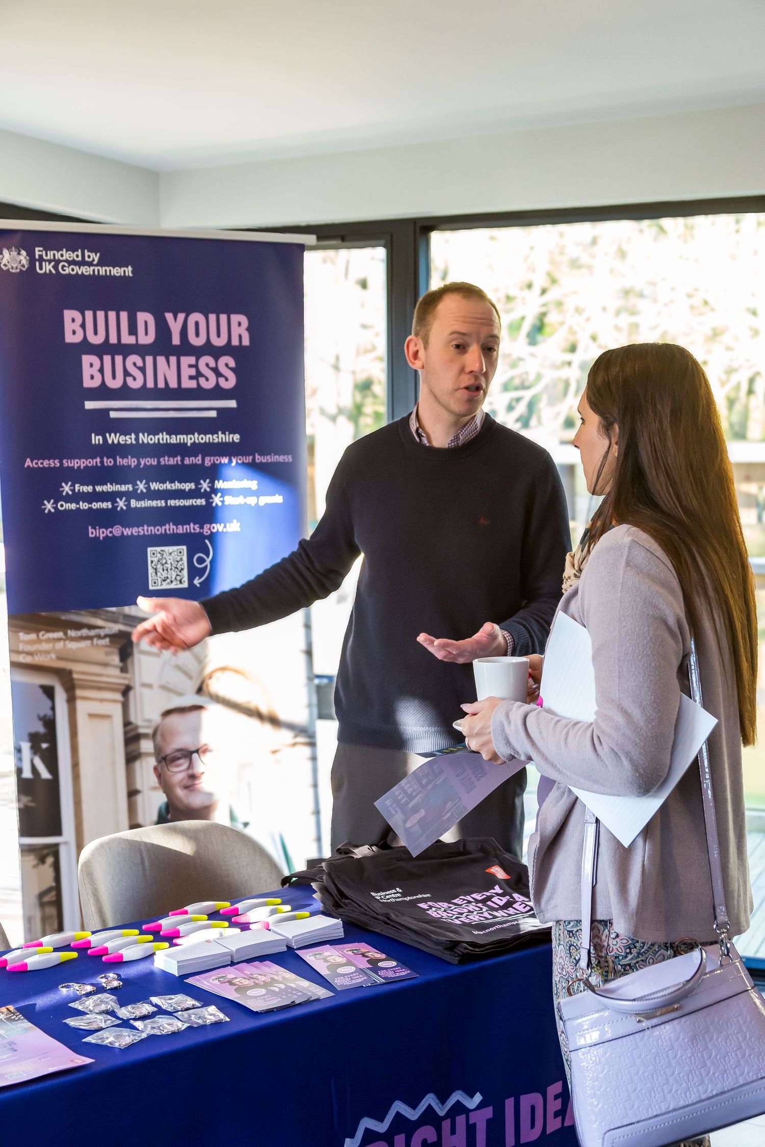 Business advisor presenting Build Your Business West Northamptonshire program at networking event.