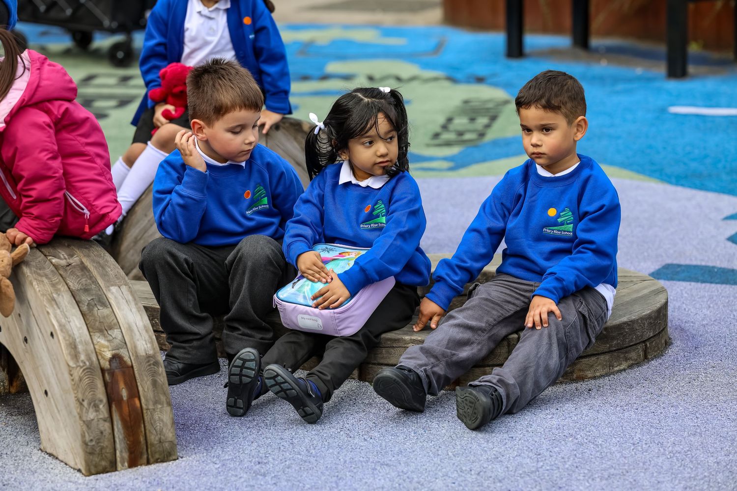 Three young children in blue school uniforms - photographed by LJPhotostop for school website content.
