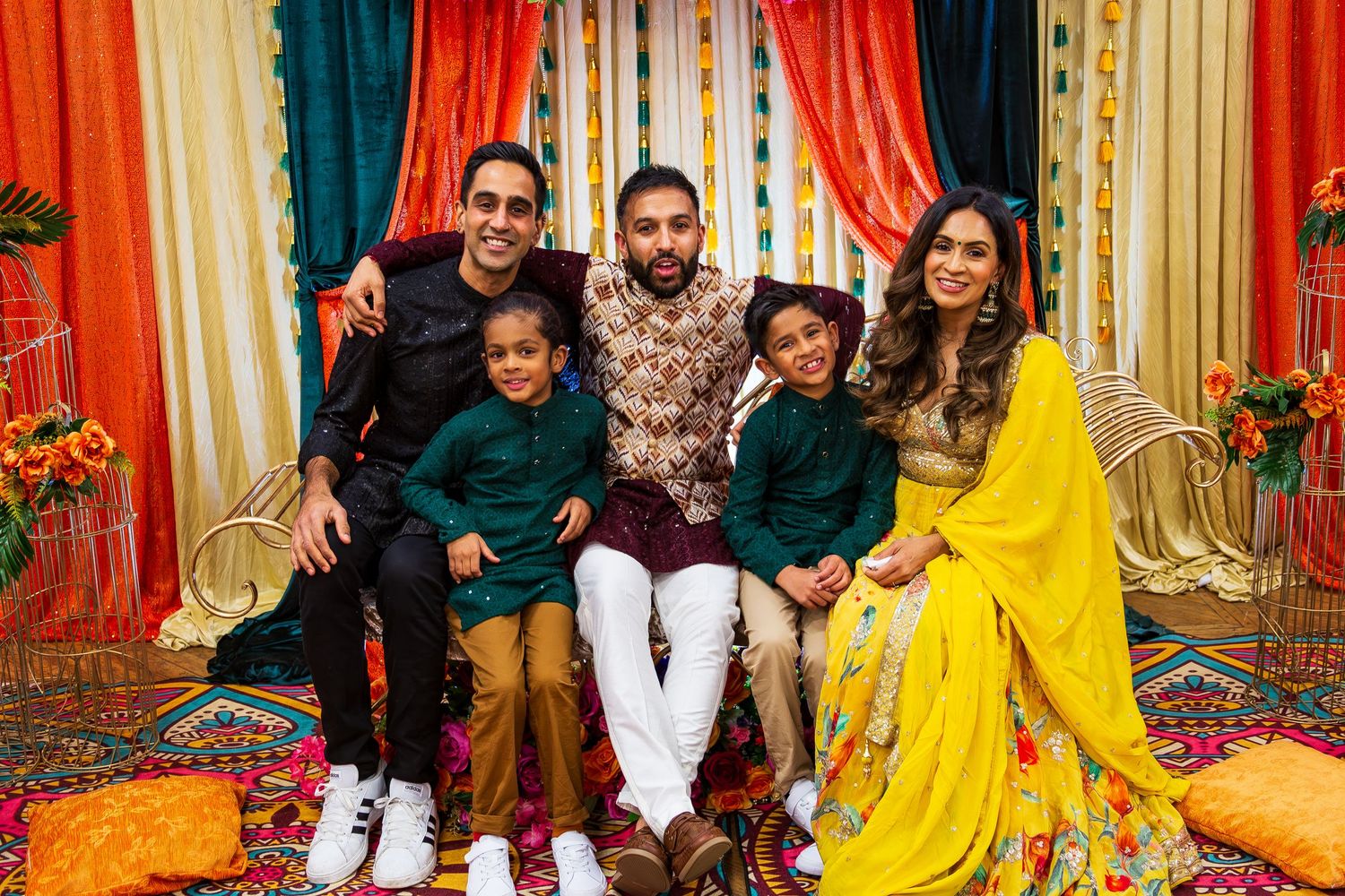 Family together in colourful traditional festive celebration with vibrant orange and teal decor. Photographed by LJPhotostop in the UK.