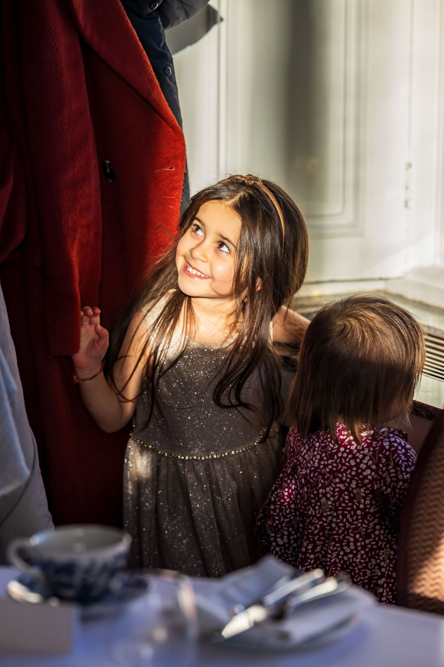 Young girl in grey dress smiling at formal event.