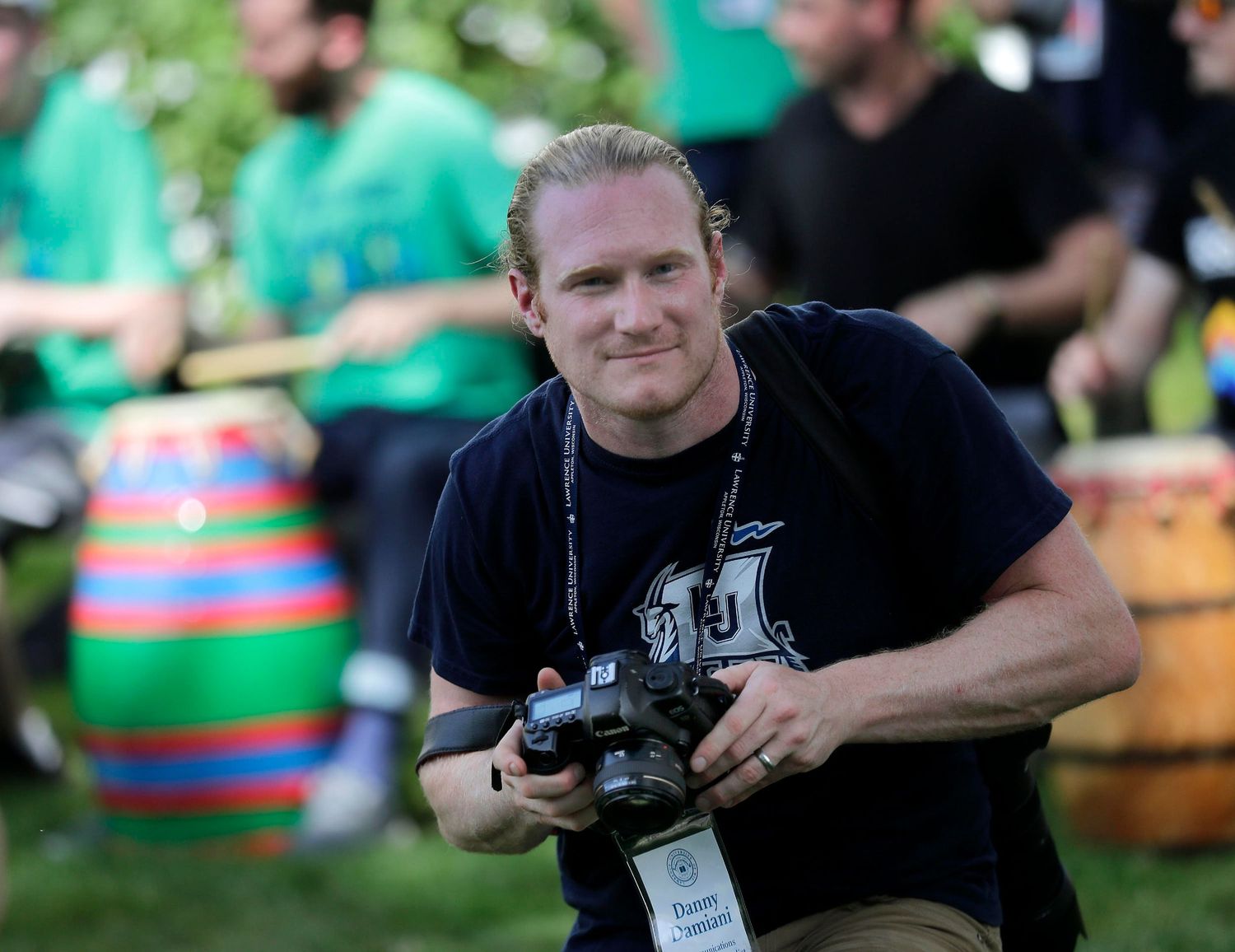Danny Damiani holds a camera while taking photos at a music event.