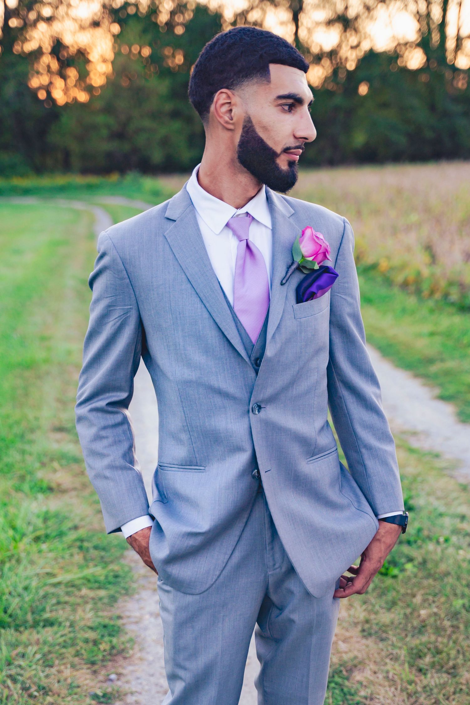 Portrait of the groom on his wedding day in a grey suit with a lavender tie.