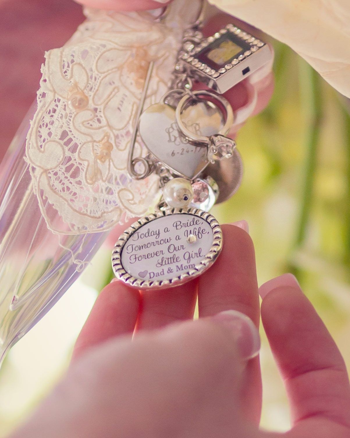A keepsake trinket on a bridal bouquet saying 