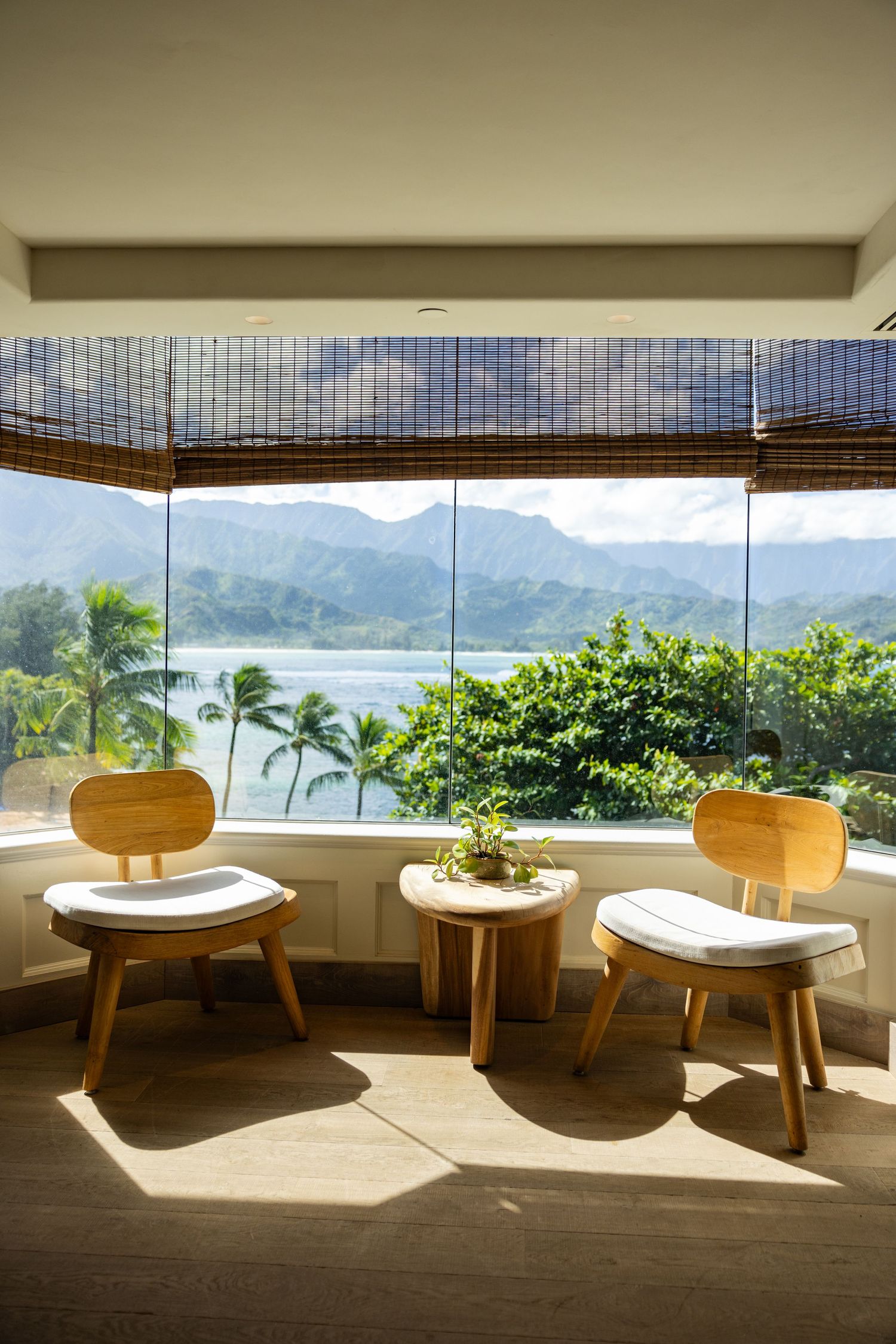 Modern seating area with panoramic views of tropical mountains and palm trees.