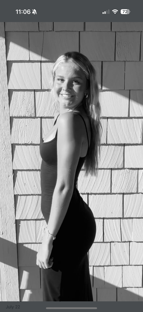 Black and white portrait series showing a person in a dark tank top posing against a white brick wall in natural light.