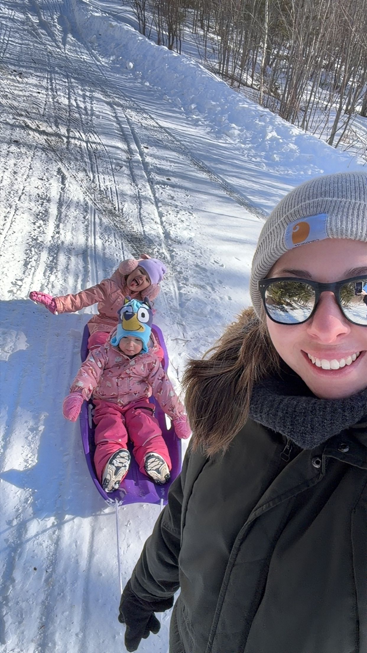 Winter selfies on a snowy slope showing someone in winter gear with a colorful stuffed animal.