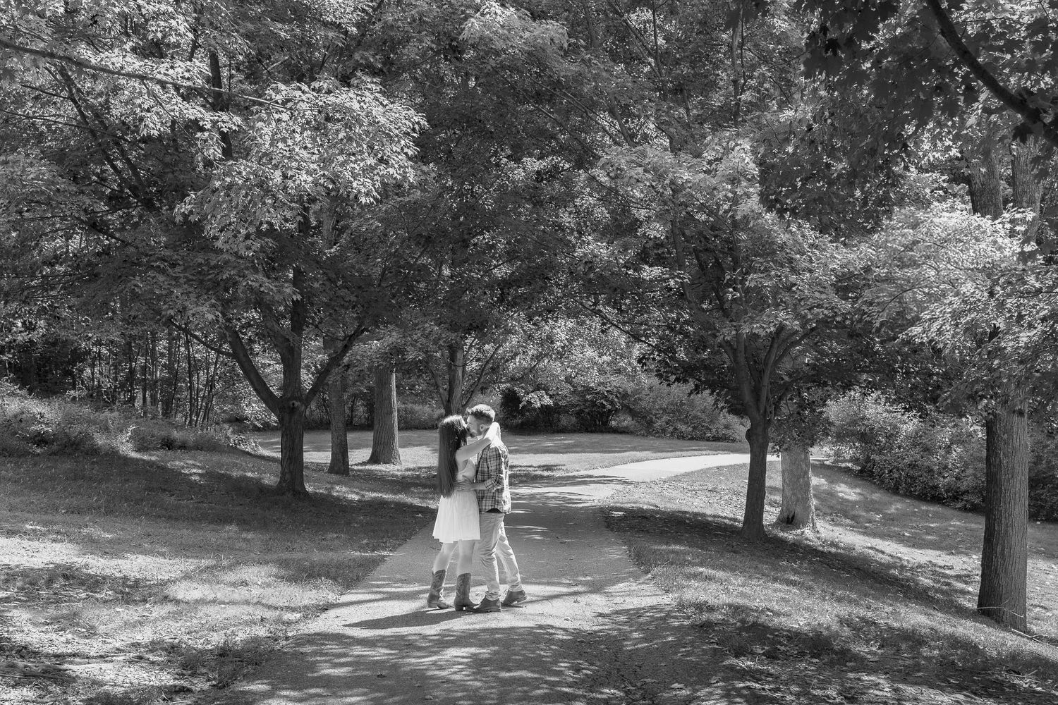 Couple embracing beneath the trees at Wolfs Hollow Park during an engagement photography session in Pennsylvania