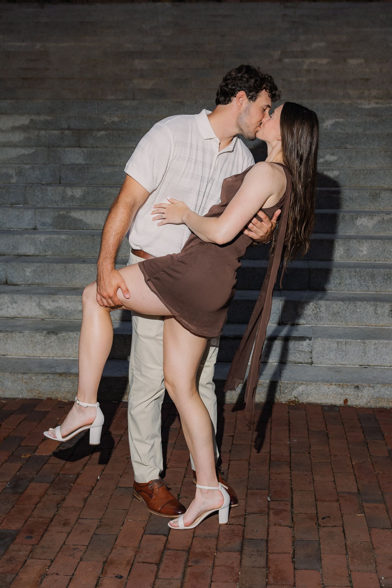 Engaged couple sharing a playful dip and kiss during a downtown Lancaster, Pennsylvania engagement photography session.