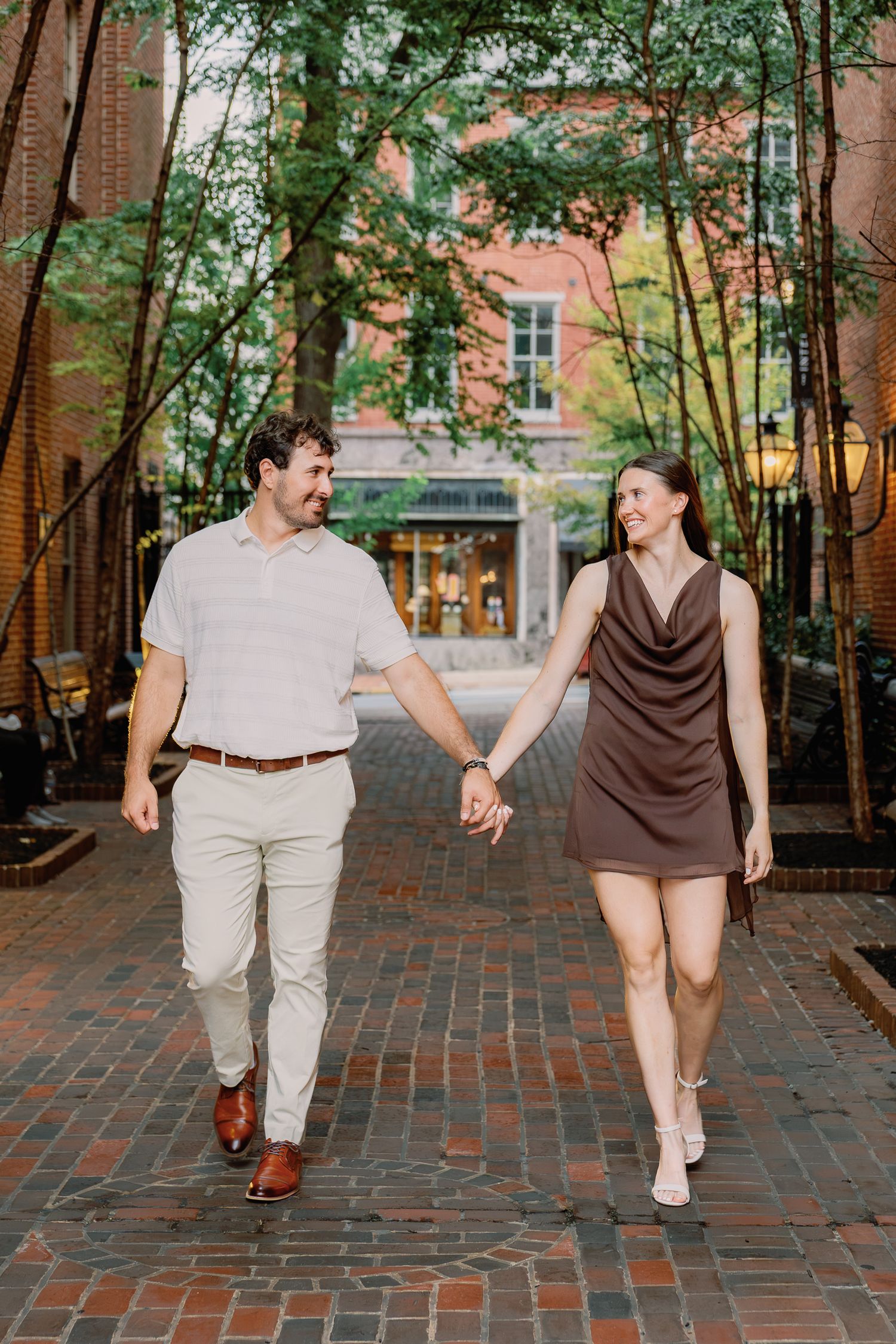 Engaged couple walking hand in hand during an engagement photography session in downtown Lancaster, Pennsylvania