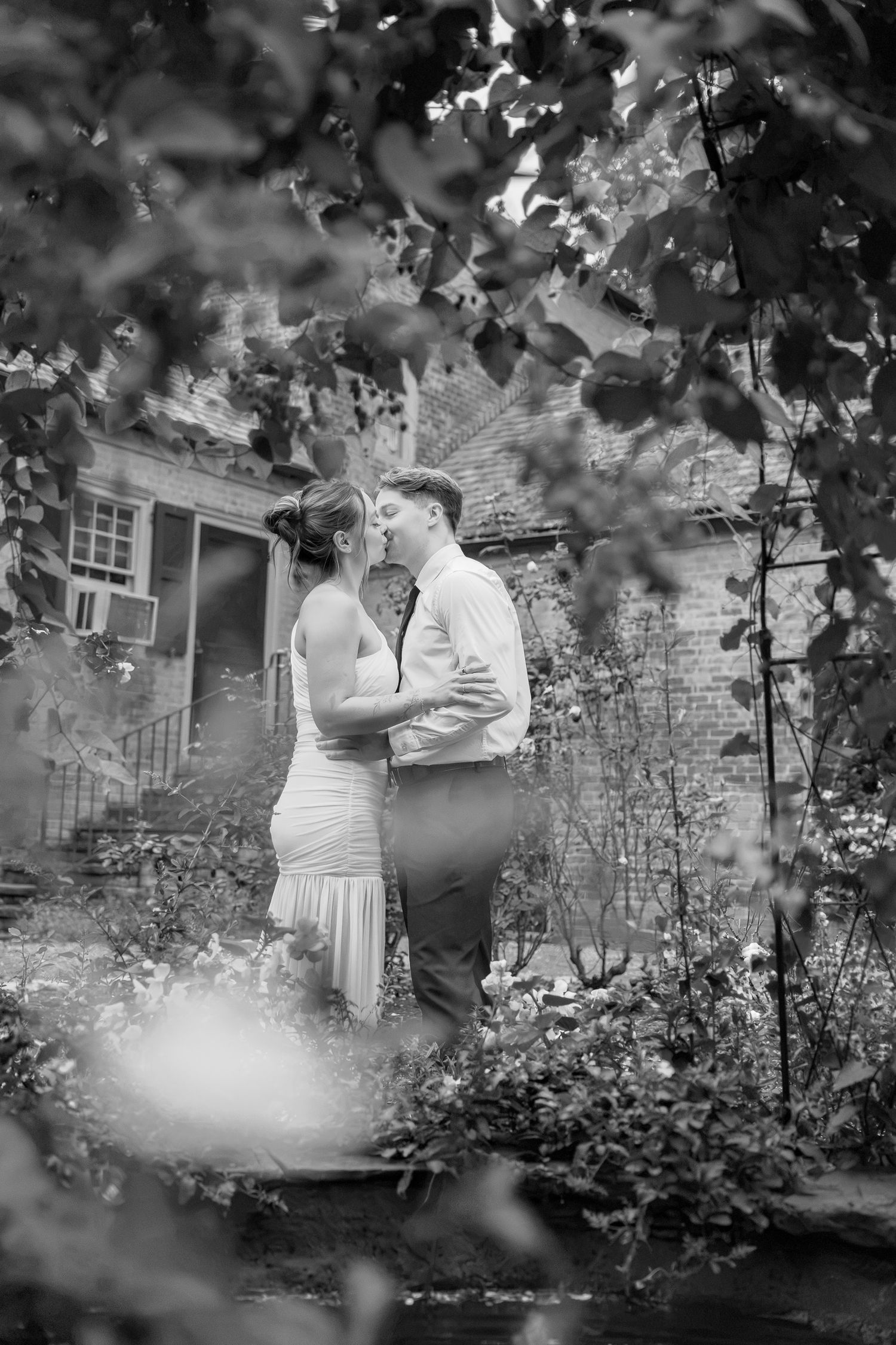 Engaged couple surrounded by lush greenery at Conestoga House and Gardens during an engagement photography session in Lancaster, PA