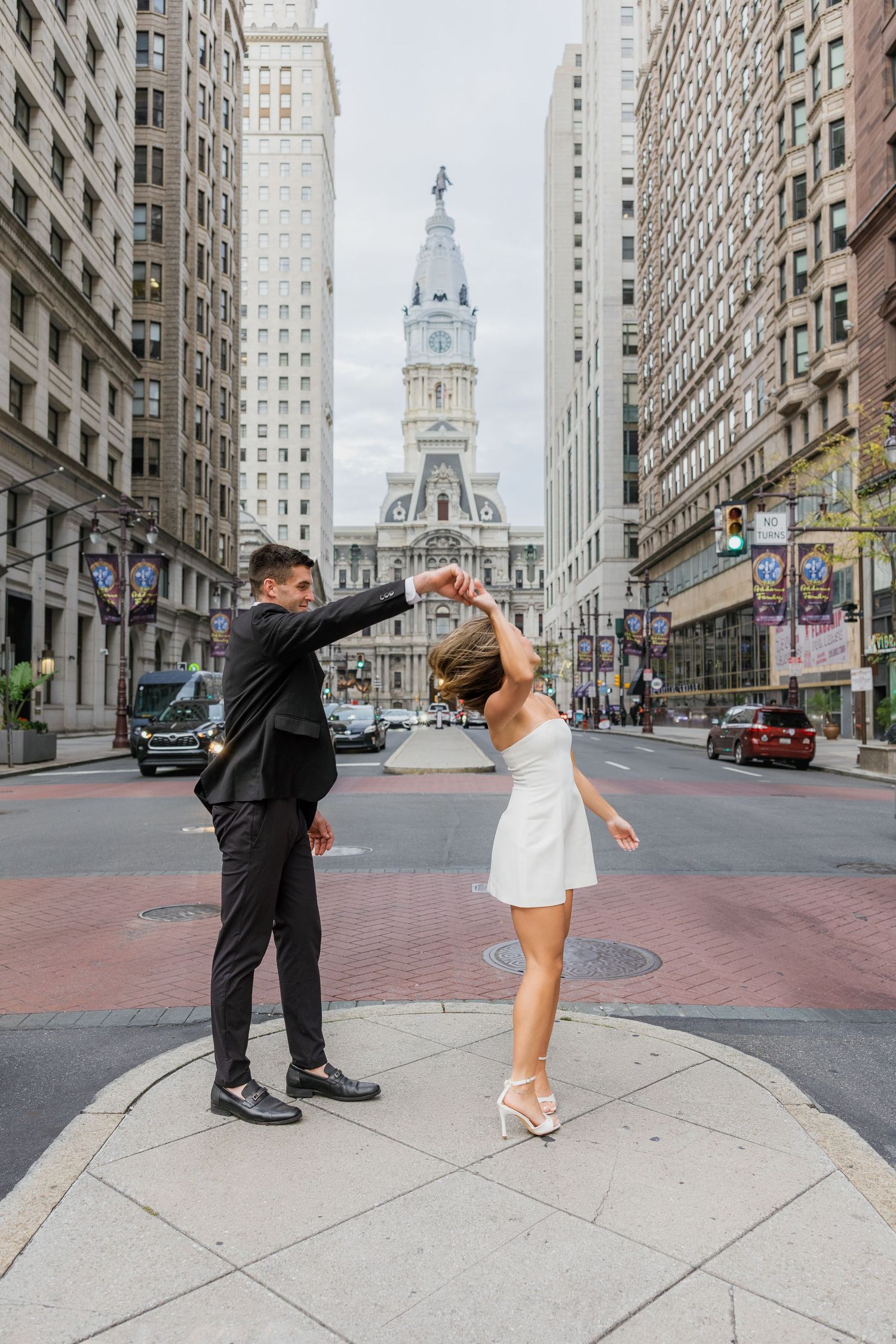 Couple holding hands on a downtown Philadelphia street during their editorial-inspired engagement photo session.