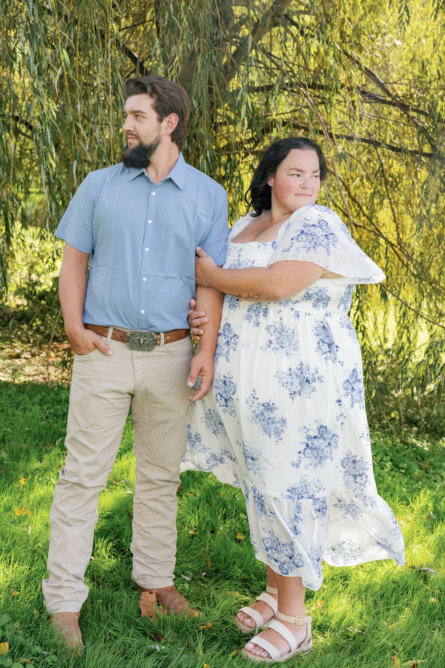 Married couple posing together in a sunlit field during their Pennsylvania anniversary photography session