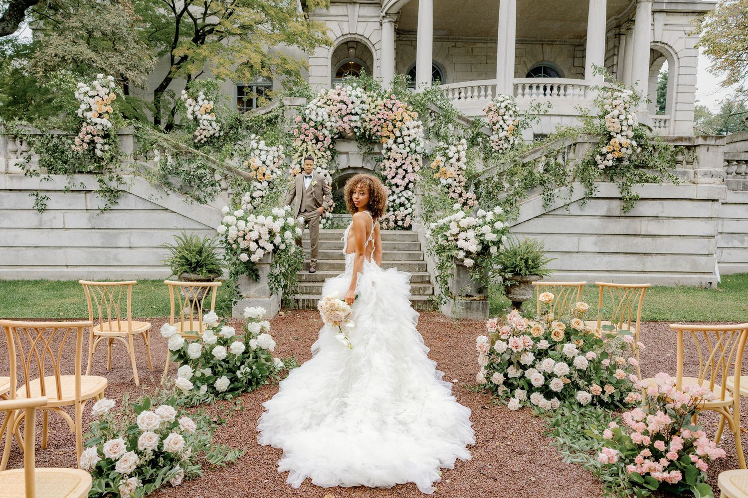 Bride walking through a lush floral wedding ceremony at Elkins Estate, a historic wedding venue near Philadelphia, Pennsylvania.