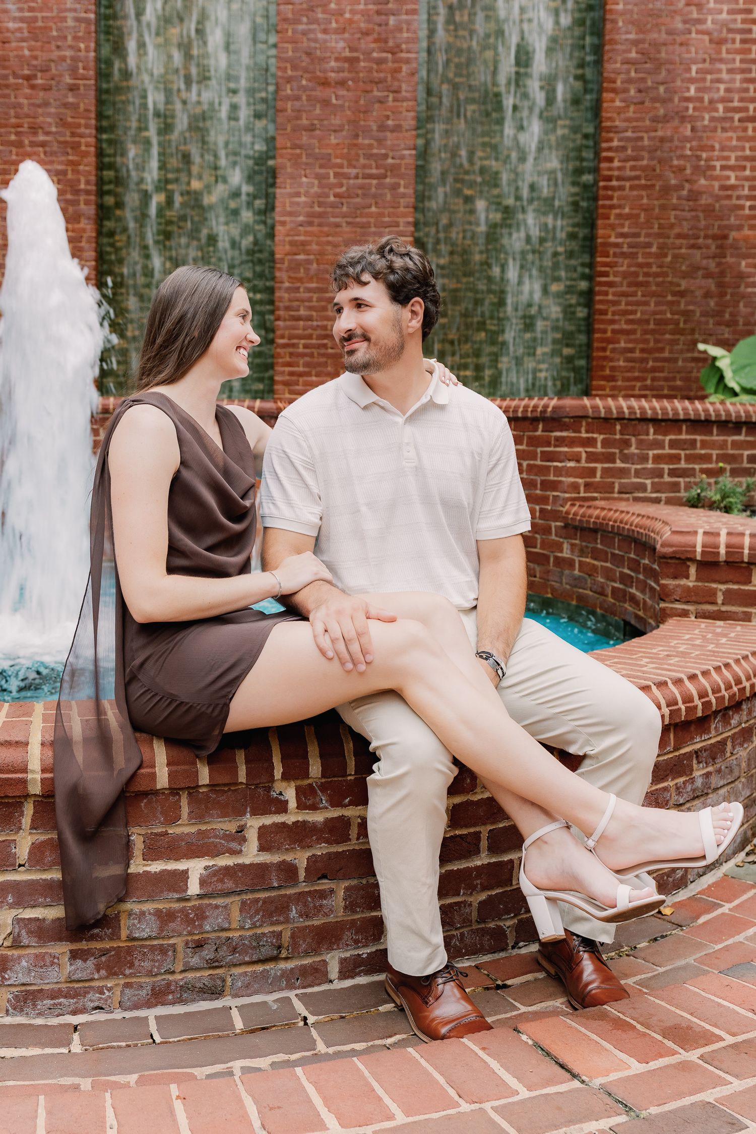 Engaged couple sitting together on brick steps during a downtown Lancaster, Pennsylvania couples photography session.
