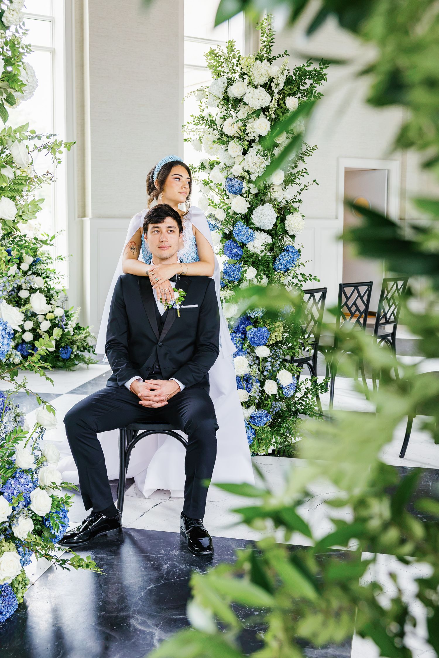 Editorial bride and groom portrait surrounded by greenery inside Elkins Estate, a historic wedding venue near Philadelphia.